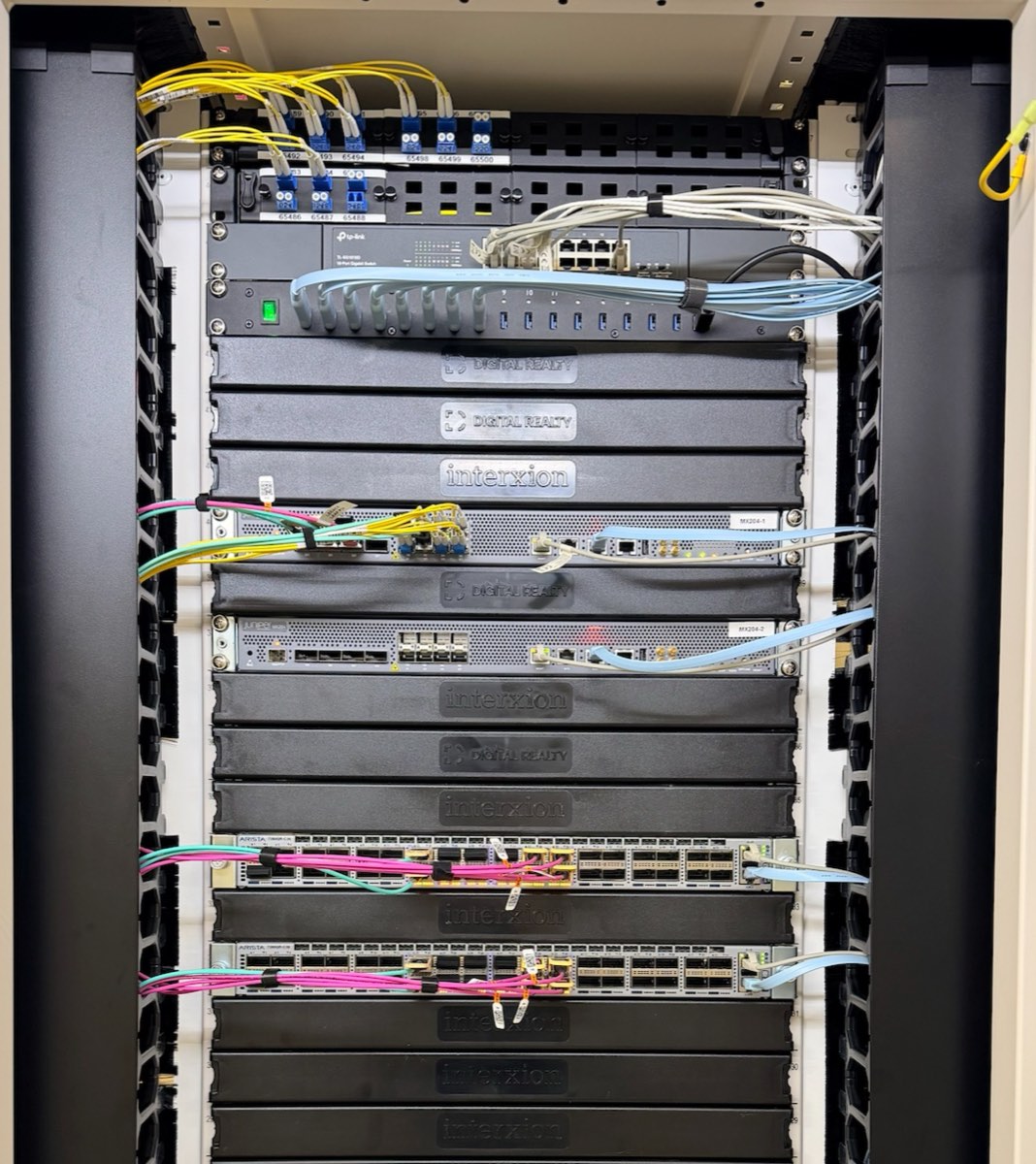 Rack de red del core de GINERNET con routers y switches cableados con fibra óptica